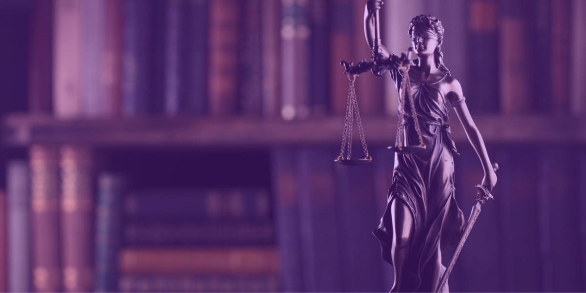 tarefas que a IA para advogados pode te ajudar A Deusa da Justiça e vários livros sobre o Direito na estante.