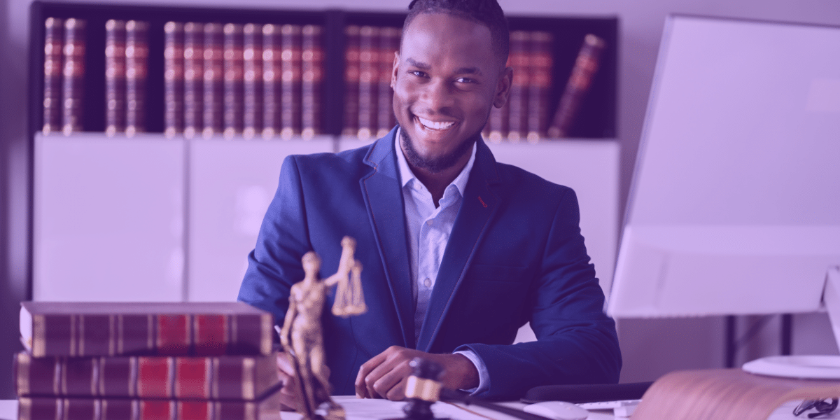 Lei 14.992/2024 Um homem negro sorrindo em um escritório de advogacia.