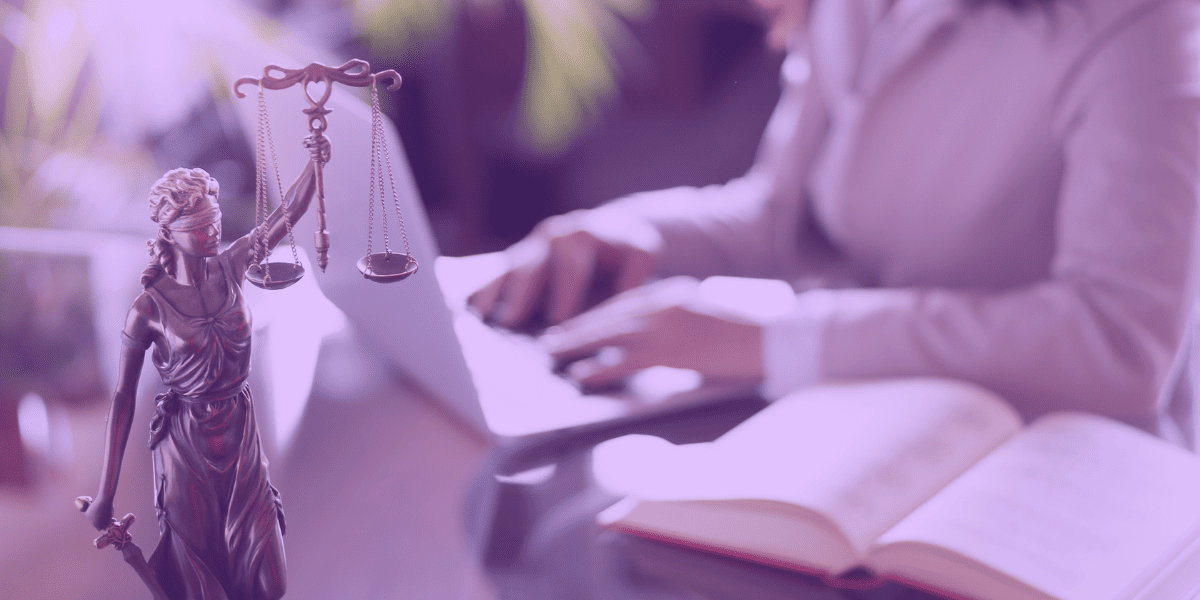 Modelo de Contrato de Prestação de Serviço A imagem retrata uma estátua da deusa da Justiça, que segura uma balança equilibrada em uma das mãos, simbolizando a imparcialidade e a equidade no julgamento. Ao fundo, desfocado, há uma pessoa digitando em um notebook, ao lado de um livro jurídico aberto, sugerindo a redação de documentos legais, como um Modelo de Contrato de Prestação de Serviço. A composição destaca a seriedade e a precisão que o ambiente jurídico demanda, refletindo a busca por soluções legais bem estruturadas.