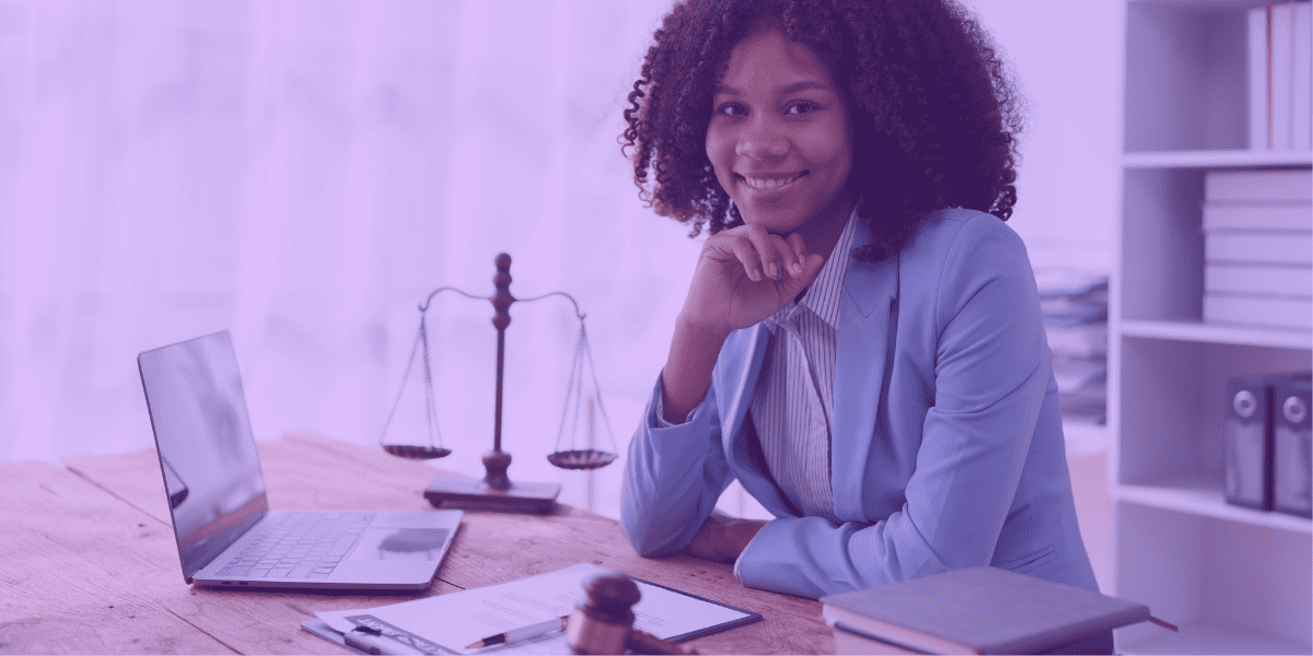 gratuidade de justiça cpc Na imagem, uma advogada sorri confiante em seu ambiente de trabalho, com um laptop, documentos e um martelo de juiz à sua frente. Ao fundo, a balança da justiça, símbolo do equilíbrio e imparcialidade no direito, reforça o contexto jurídico. A "gratuidade de justiça", conforme prevista no CPC (Código de Processo Civil), pode ser um tema relevante nesse cenário, uma vez que advogados muitas vezes orientam seus clientes sobre a possibilidade de solicitar esse benefício. Ele permite que pessoas sem recursos suficientes possam ter acesso à justiça sem arcar com custos processuais, assegurando um julgamento justo e equitativo.