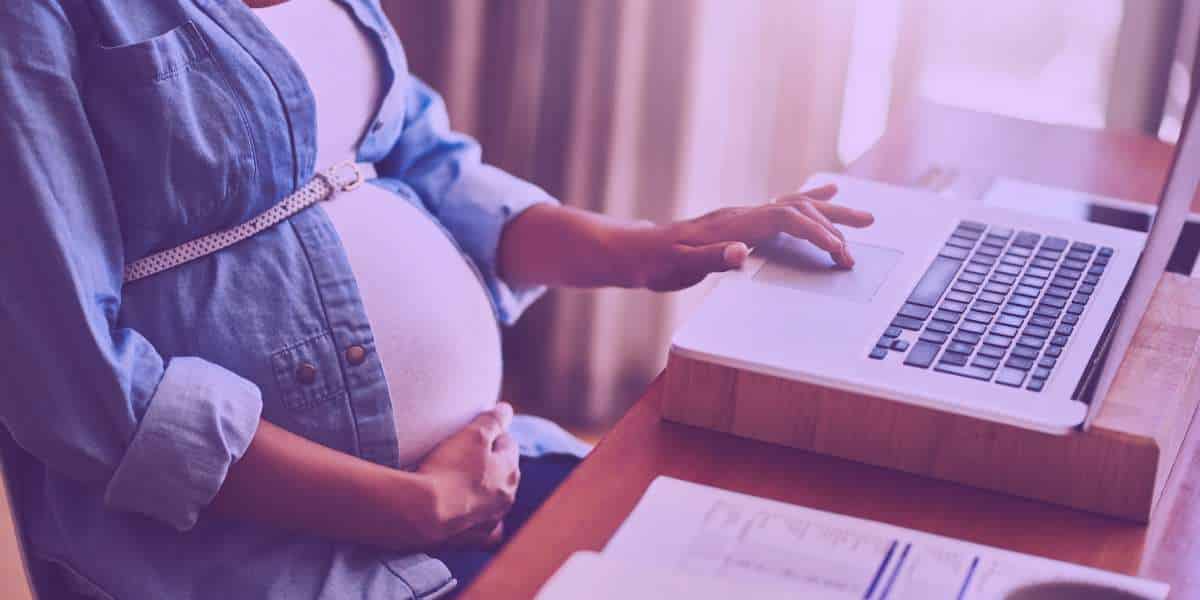 Mulher grávida pesquisando sobre o salário-maternidade