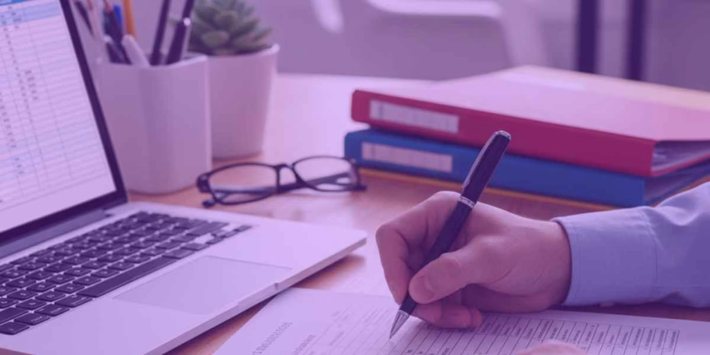 Uma mesa de trabalho organizada com documentos, calculadora e notebook, sugerindo um ambiente propício para renegociação de dívidas.