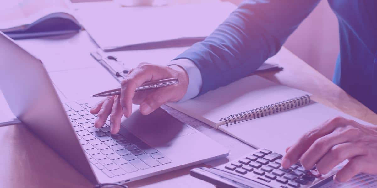 Recuperação de Crédito para Empresas Advogado analisando dados financeiros em um notebook e calculadora, simbolizando estratégias de Recuperação de Crédito para Empresas.