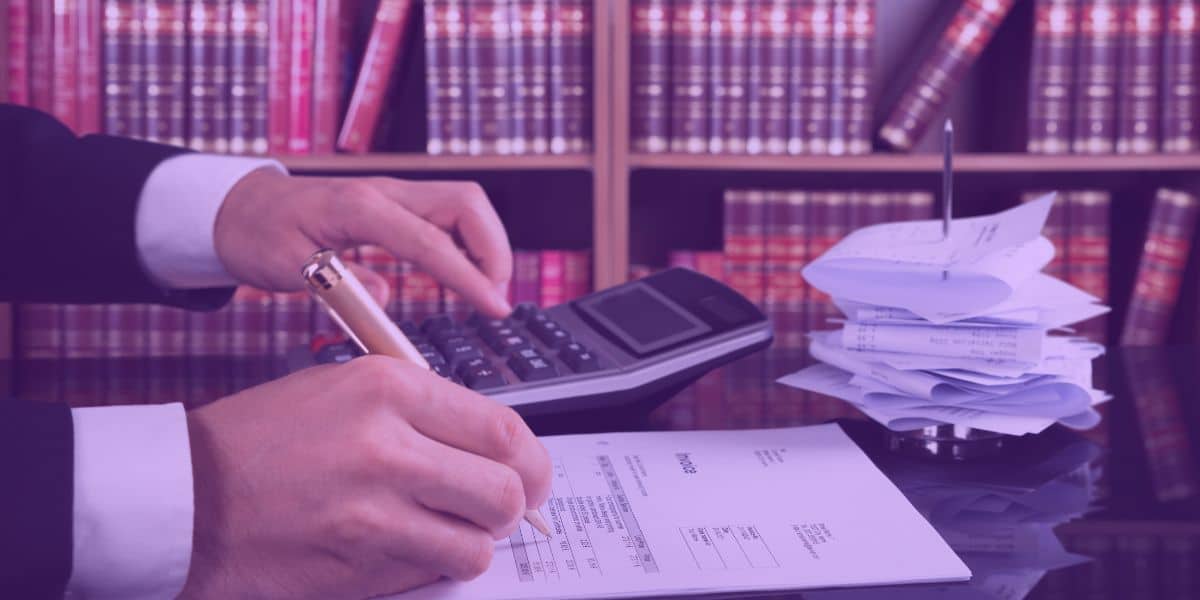 renegociacao-de-dividas Um advogado em um escritório, revisando documentos e utilizando uma calculadora, simbolizando o processo de renegociação de dívidas.
